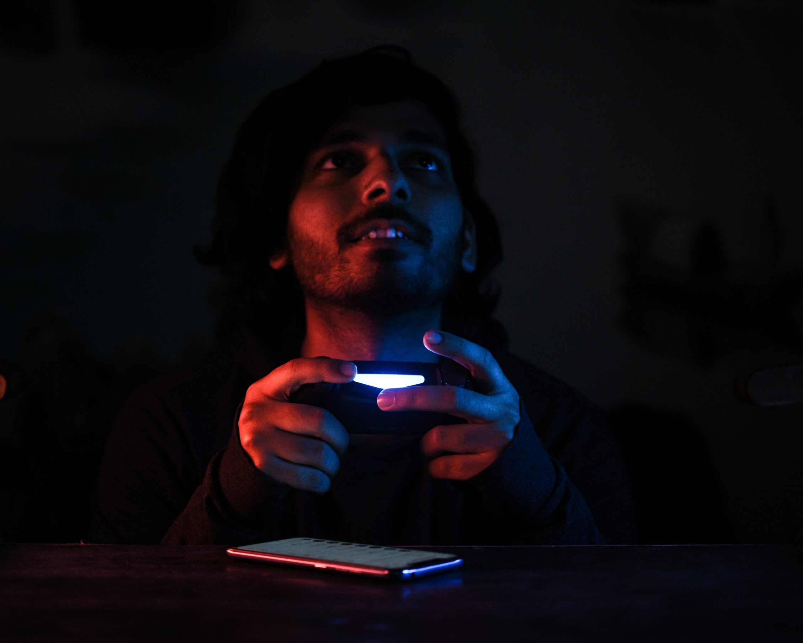 Gamer face illuminated by computer screen in dark room - Gamer on PS4