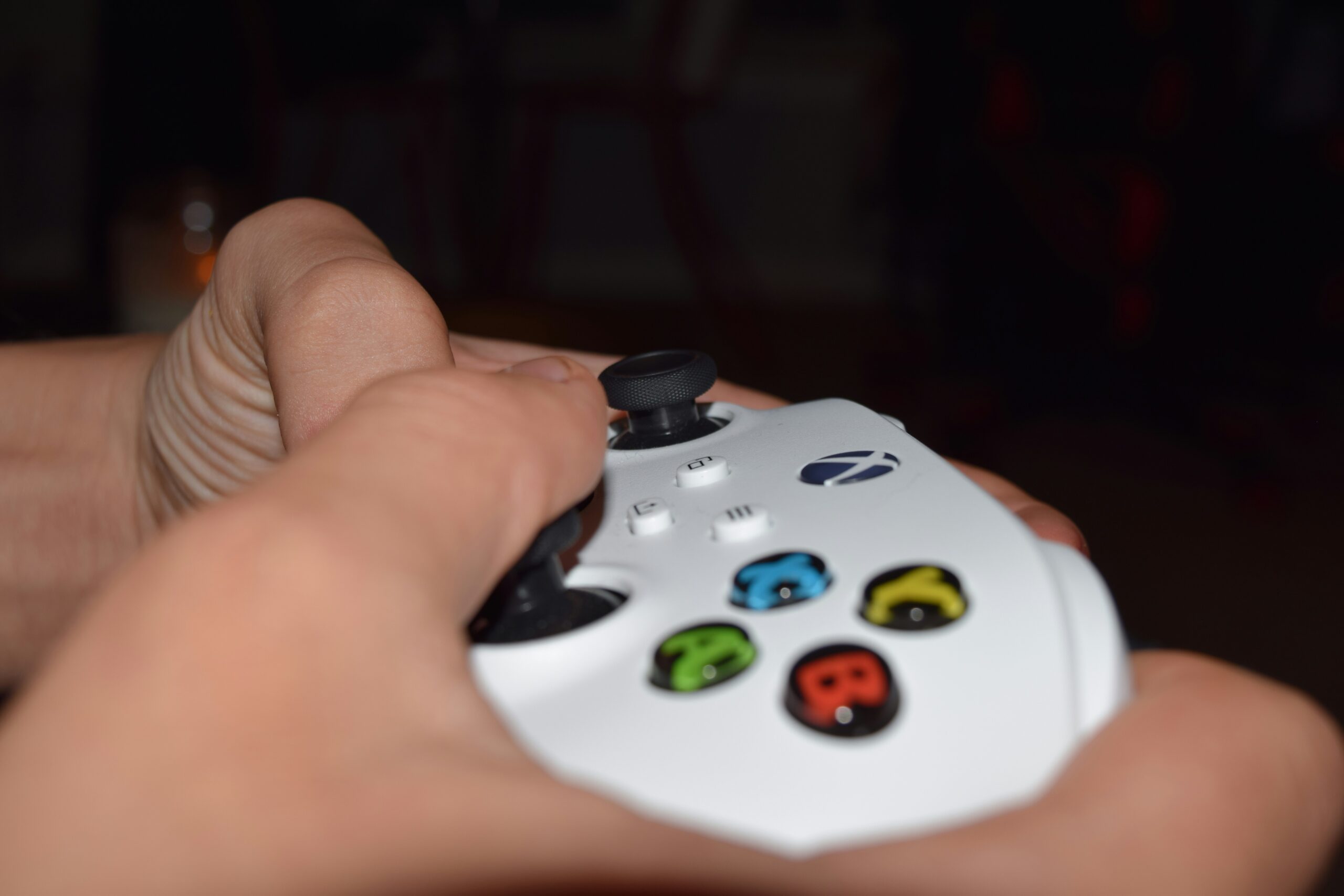 close up hands on gaming controller - a person holding a video game controller