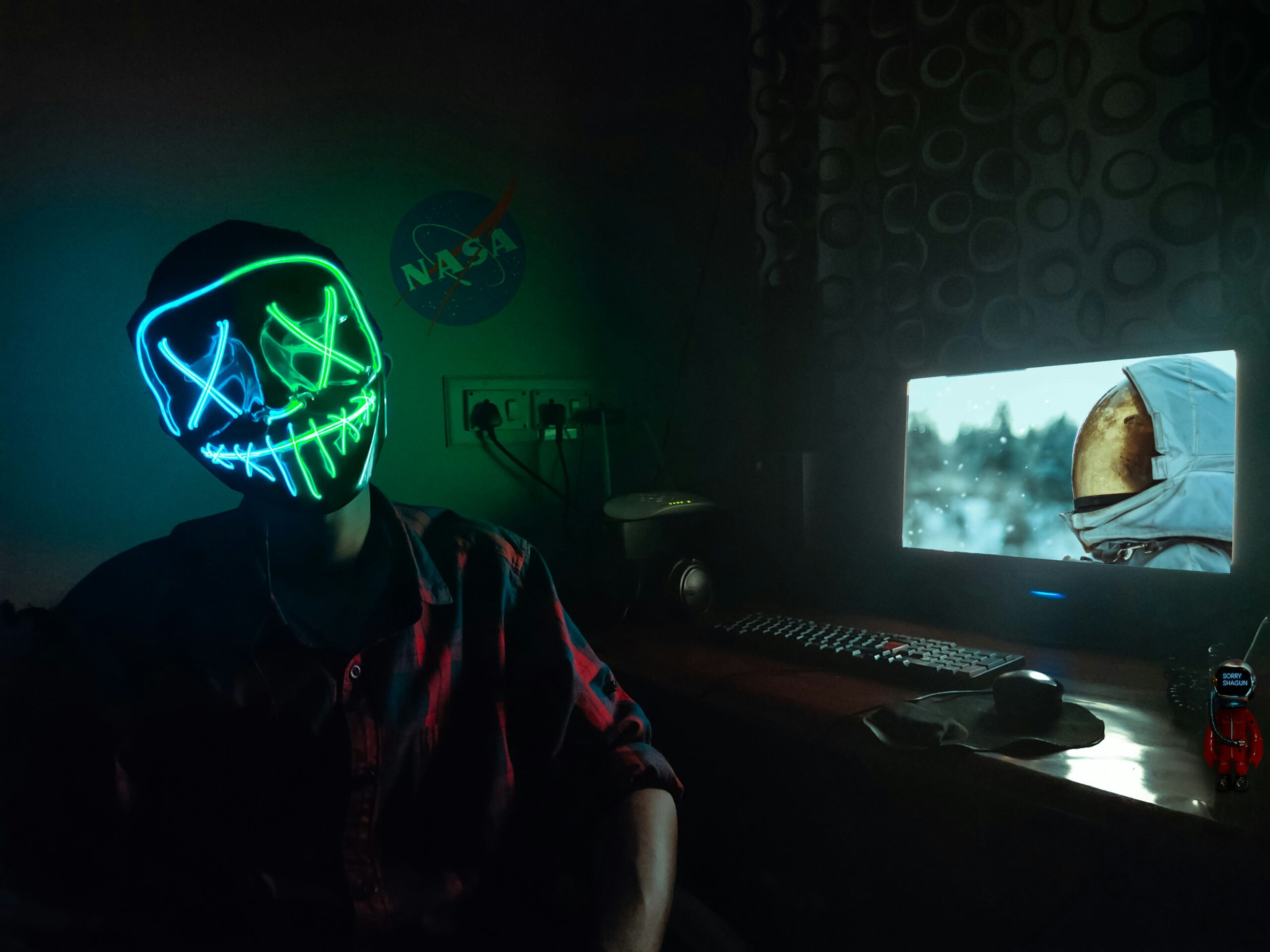 angry gamer yelling at computer screen - Person wearing Led Mask sitting in front of computer.