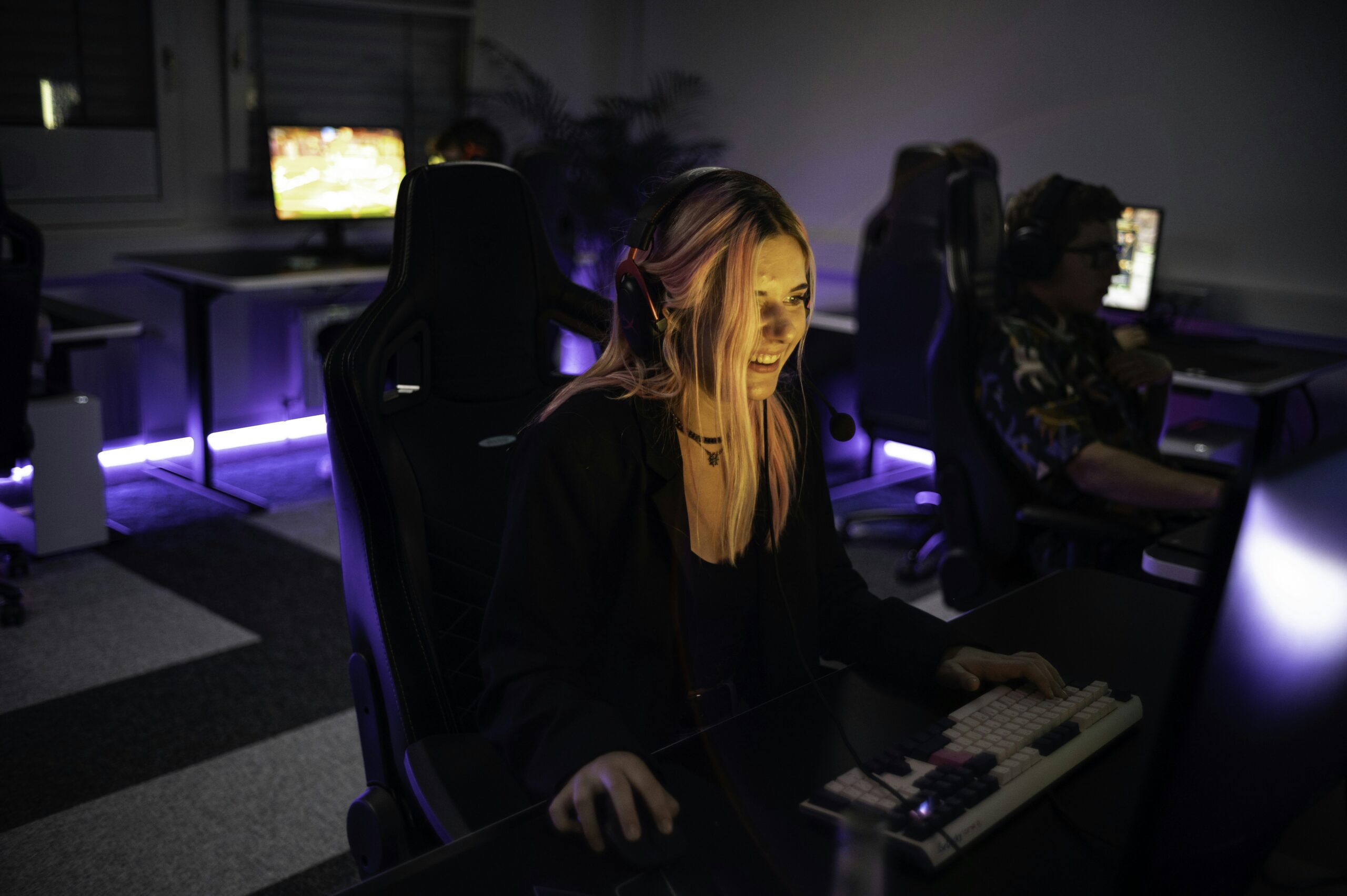 Gamer face illuminated by computer screen in dark room - 1337Camp offers a unique environment perfectly tailored to the needs of gamers and creatives. Our facility features customizable lighting and LED floor lights that change colors to create the ideal atmosphere. The dojo-like design of the camp promotes a balance of relaxation and focus, allowing you to actively unwind while staying driven towards your goals. At 1337Camp, technology and design come together to create an inspiring and productive space that empowers you to reach your full potential.